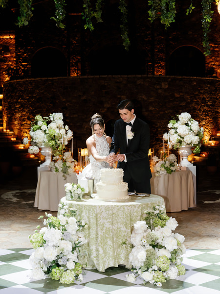 Bride and groom cutting their wedding cake on the patterned dance floor
