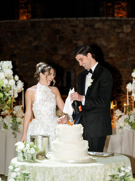 Bride and groom sharing a joyful moment while cutting their wedding cake