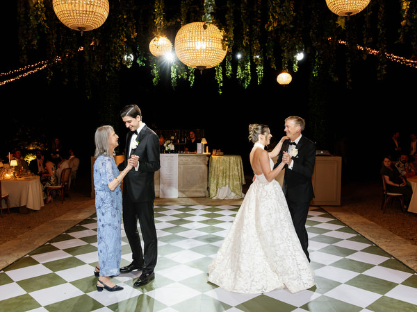 Newlyweds dancing together on the patterned floor during the late-night reception