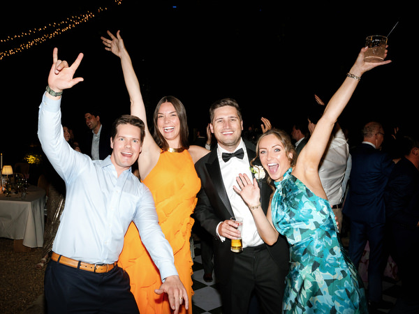 Wedding guests raising their arms and celebrating on the dance floor