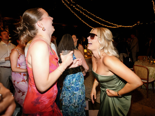 Wedding guests laughing and singing together on the dance floor