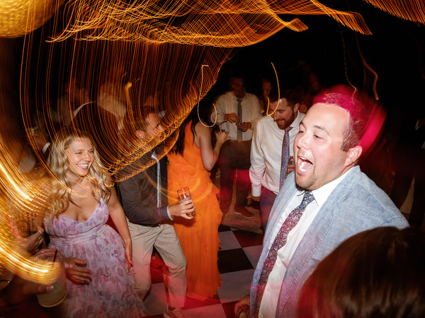 Wedding guest dancing beneath warm lights during the late-night party