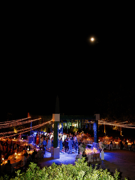 Night view of the outdoor Pyrgos Petreza reception glowing beneath string lights