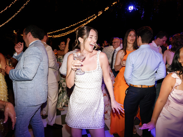 Wedding guests dancing beneath string lights during the evening celebration