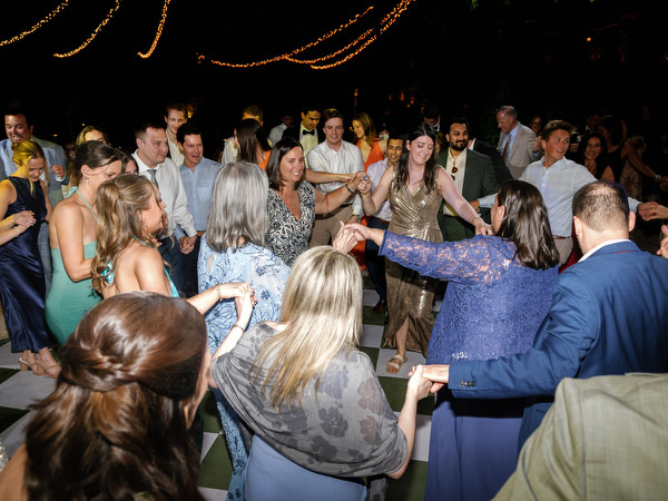 Guests celebrating in a circle on the dance floor beneath warm lights