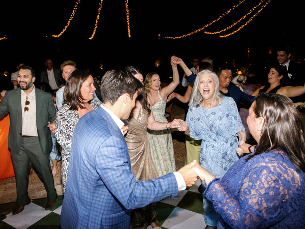 Wedding guests dancing together during the lively destination wedding celebration