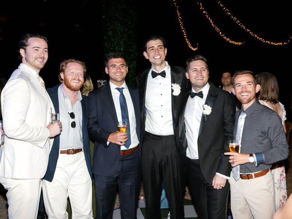 Group of male wedding guests posing together during the evening reception