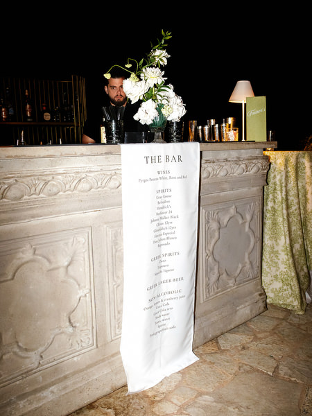 Elegant wedding seating chart displayed on a decorative stone table at night